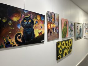 Eine Wand mit Acrylbildern, die im Ludgerus-Werk ausgestellt werden. 