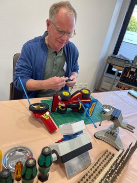 Ein Mitarbeiter des Repair-Café werkelt an einem ferngesteuerten Auto.