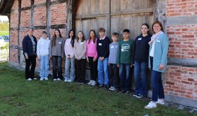Die Gruppe Teilnehmer*innen am Zukunftstag stehen mit Betreuerin Britta von Lehmden vor der Hofstelle des Ludgerus-Werk. 