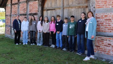 Die Gruppe Teilnehmer*innen am Zukunftstag stehen mit Betreuerin Britta von Lehmden vor der Hofstelle des Ludgerus-Werk. 