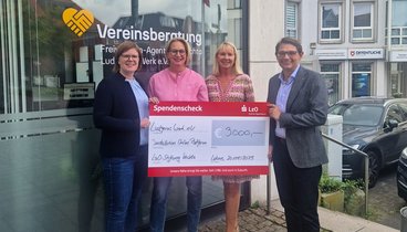 Vier Personen stehen vor dem Büro der Vereinsberatung in Lohne und halten einen symbolischen Check über 2000 Euro in den Händen. 