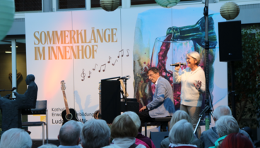 Martina Halbritter und Theo Hartogh auf der Bühne im Innenhof des Ludgerus-Werk. 