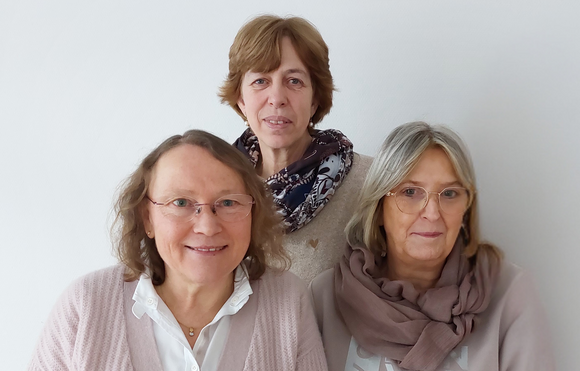 Das Team des Seniorentreffpunkts steht vor einer weißen Wand. 