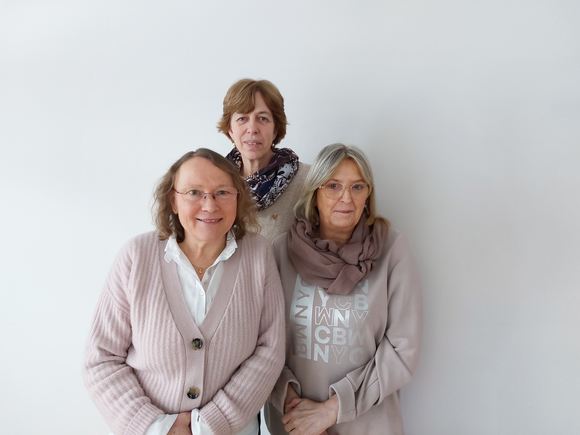 Das Team des Seniorentreffpunkts steht vor einer weißen Wand. 